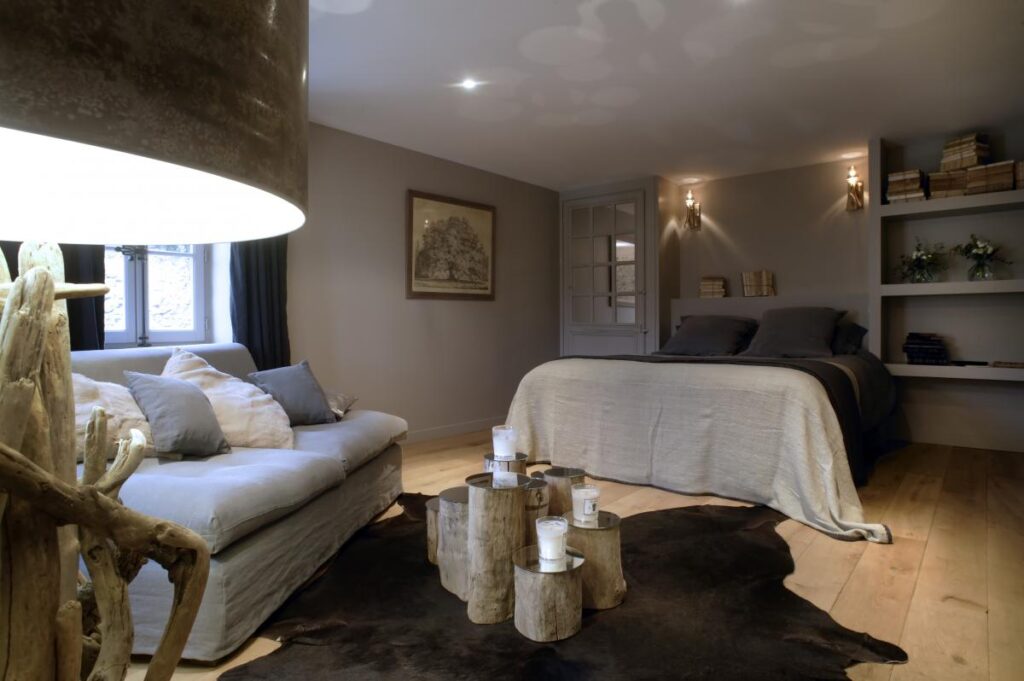 chambre cosy avec draps de lit en lin lavé très confortable et table basse en tronc d'arbres dans le salon