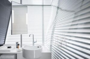 Coin salle de bain de la chambre avec vitres et persiennes incurvées