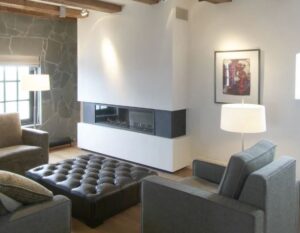 Salon cosy avec grande cheminée insert au gaz dans la suite 4