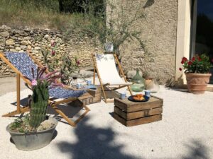 Salon extérieur avec chiliennes et tables en bois La Serallère au coeur des oliviers gite Baronnies Provençales