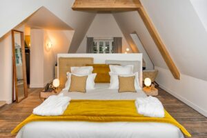Chambre Biggy Suite avec un lit double couleur blanc et jaune or