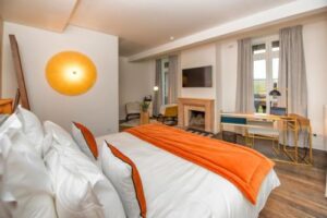 Chambre double Cosy couleur blanc et orange avec un coin salon