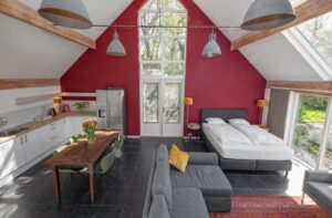 Studio avec un lit double, un coin salon, une cuisine ouverte avec coin repas