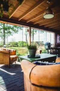 Séjour commun avec coin salon et coin repas donnant sur le jardin - De Bedstay - Chambre d'hôtes