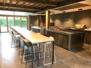 Cuisine ouverte avec grande table haute et tabourets