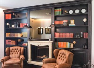 bibliothèque avec cheminée et fauteuil dans la Villa Fanny à Cagliari en Sardaigne