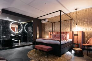 Junior suite cosy et chic avec salle de bain ouverte en marbre noir