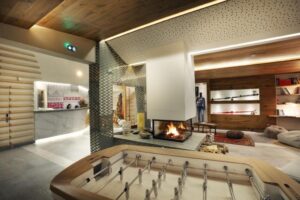 Baby-foot et salon avec cheminée dans le lobby de l'hôtel Pashmina Val Thorens