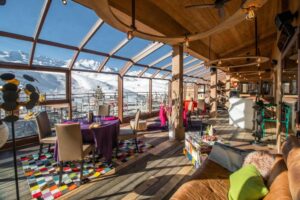 Restaurant lumineux et cosy avec verrière et vue sur les montagnes