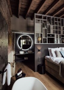chambre style industriel cosy avec salle de bain ouverte et mur en brique