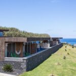 Vue extérieure des villas et de leur terrasse. Le bâtiment est construit pour se fondre dans le paysage de l'île avec son toit terrasse