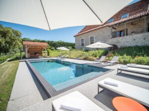 piscine extérieure chauffée avec transat dans le jardin donnant sur les champs de la campagne avoisinante