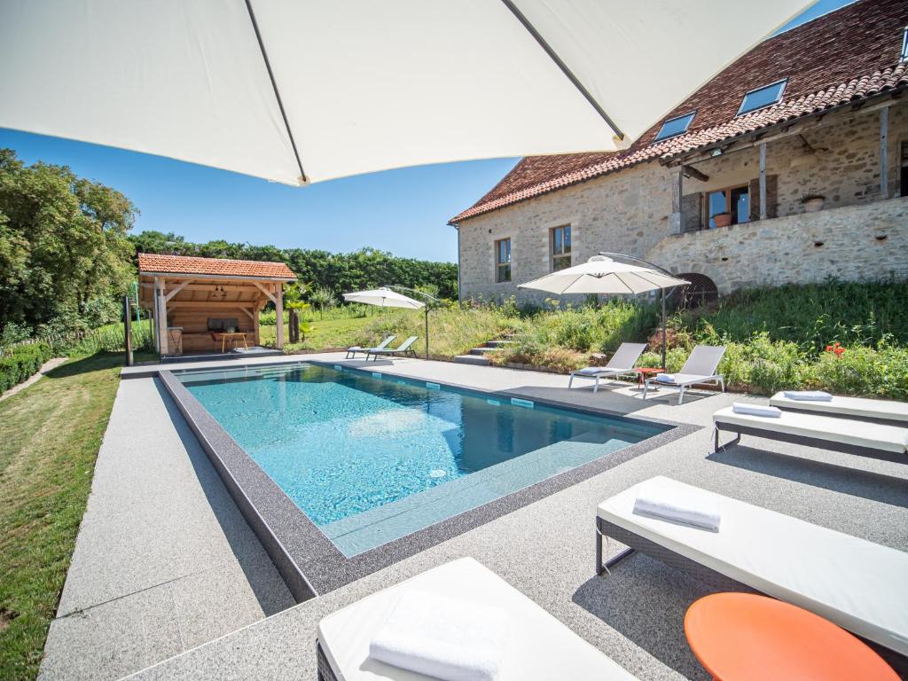 piscine extérieure chauffée avec transat dans le jardin donnant sur les champs de la campagne avoisinante
