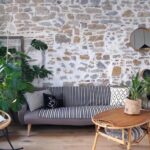 Salon avec mur en pierre apparente et parquet au sol pour cet appartement typique à la location touristique dans le Vieux Lyon