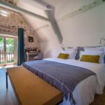 chambre au style maison de famille, campagne, avec mur en pierres apparentes et poutres