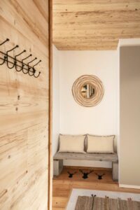Entrée avec banc pour se déchausser dans une villa cosy et confortable à louer pour les vacances