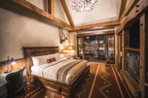 chambre double avec cheminée et terrasse à la décoration type cabane au fond de la forêt