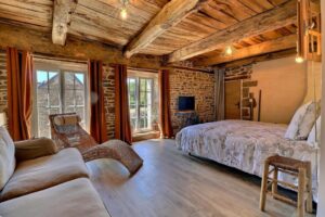 Chambre d'hôtes de charme pour une famille de 4 avec ses grandes fenêtres, poutres apparentes et mur en pierre