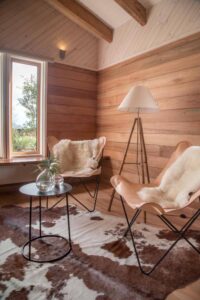 coin salon cosy et chaleureux avec un tapis en peau de vache et le bardage du mur en bois