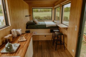 intérieur de la Tiny House avec ses grandes fenêtres pour contempler la nature