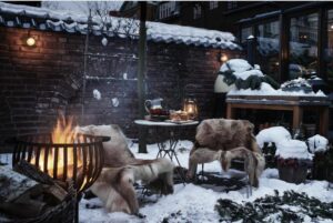 jardin enneigé et très romantique avec le brasero et les fauteuils cosy et chaleureux avec les peaux