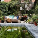 Piscine extérieure naturelle et tout en pierre se fondant parfaitement dans le jardin et dans un univers apaisant à la Maison Fred Luxury Suites à Bruges