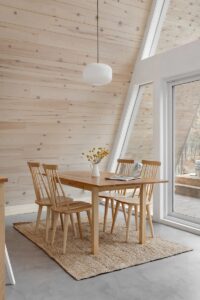 Coin repas devant la baie vitrée avec vue sur la forêt