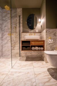 Salle de douche chic avec le marbre et la robinetterie dorée