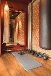 salle de sport avec tapis d'exercices, kettlebell, sac de boxe, haltères et espalier