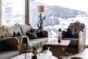 salon du bar de l'hôtel Niblea avec un mobilier tout en bois respectant la décoration d'un chalet de montagne cosy et chaleureux