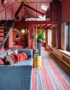 Salon d'une des suites à louer à Bruges avec une alcôve canapé et la chambre en hauteur dans la mezzanine