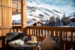 chocolat chaud sur la terrasse ensoleillée avec vue sur la montagne enneigée