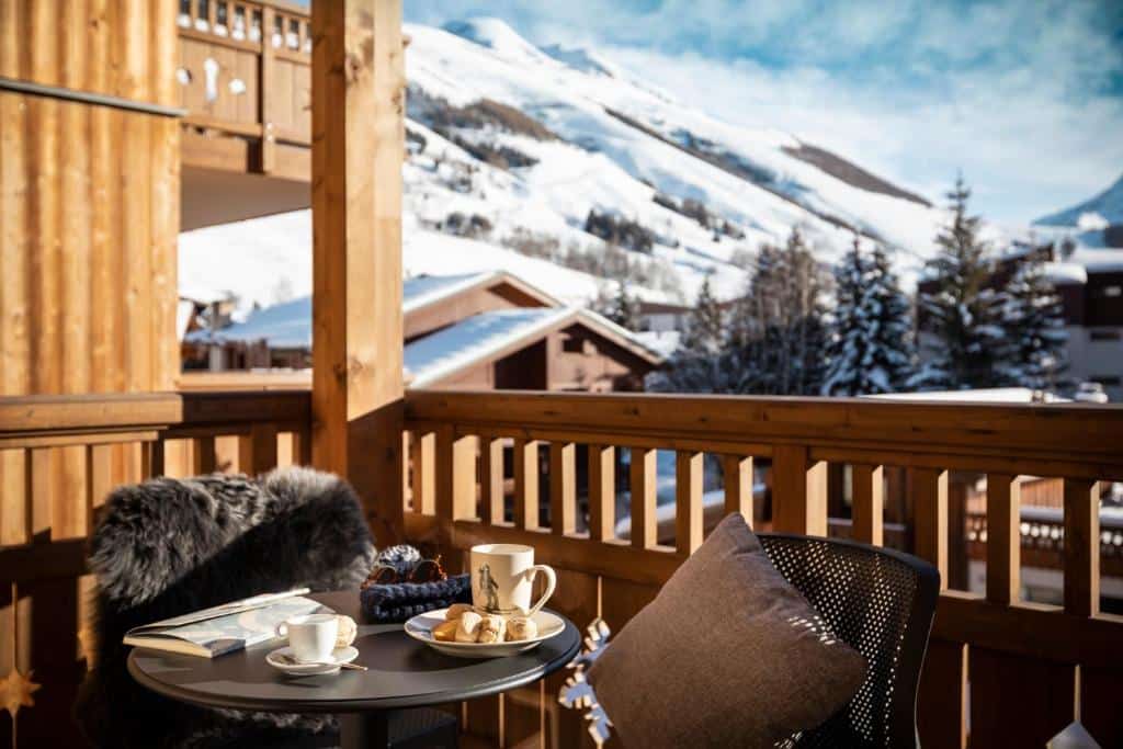 chocolat chaud sur la terrasse ensoleillée avec vue sur la montagne enneigée