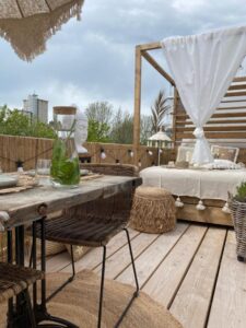 petite terrasse très bien optimisée et agencée avec un coin repas et un transat double dans une décoration bohème chic