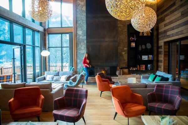 bar lounge avec cheminée et grande baie vitrée offrant une superbe vue sur les montagnes