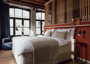 Grande chambre double lumineuse au style industriel avec les poutres et les tuyaux apparents