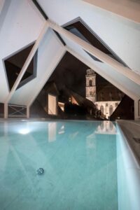 piscine sur les toits avec vue sur la Cathédrale Saint George de Dinkesbühl illuminée dans la nuit