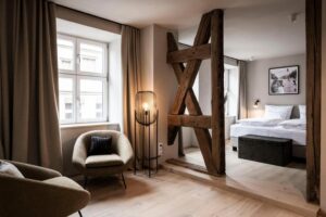Coin salon avec poutre apparente et ouvert sur la chambre d'un studio de l'hôtel Goldene Rose en Allemagne