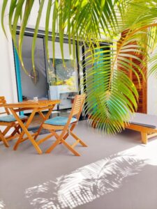 terrasse d'une chambre d'hôtes et table et transats donnant sur la piscine