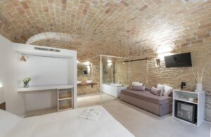 coin salon dans une chambre avec baignoire ouverte sur la chambre