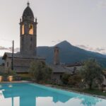 Vue sur l'église du village de Cremia depuis la piscine de l'hôtel Casa Olea