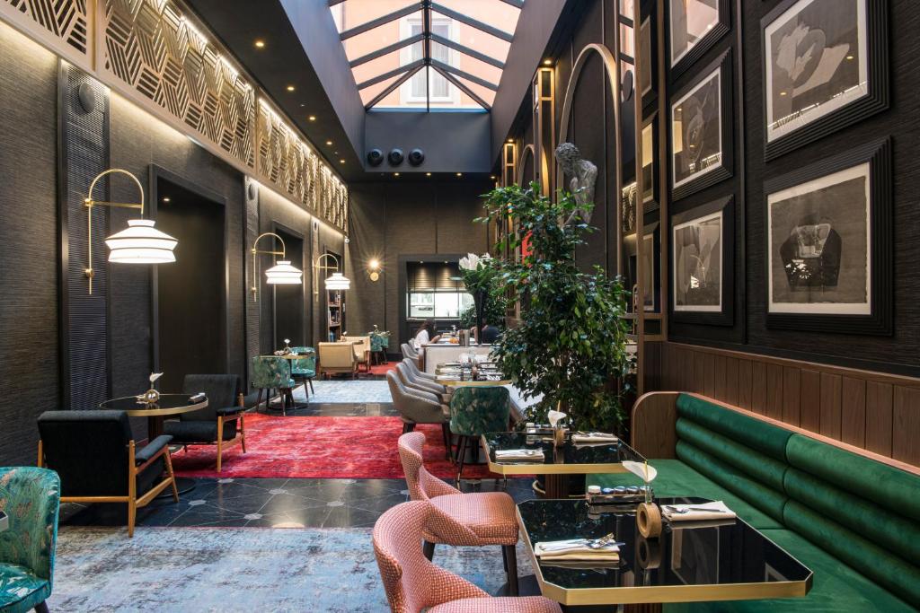 salle de restaurant sous une verrière à l'hôtel Umiltà 36 à Rome où l'on prend un délicieux petit déjeuner avant de partir en visite dans la ville