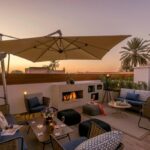 salon lounge extérieur cosy avec cheminée et vue sur les toits de Marrakech