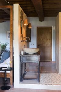 coin salle de bain avec lavabo séparé de la tête de lit par un mur