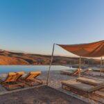 piscine et transat au coucher du soleil dans le désert d'Agafay au Maroc