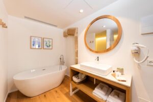 salle de bain avec baignoire ilot dans une des chambres de l'hôtel