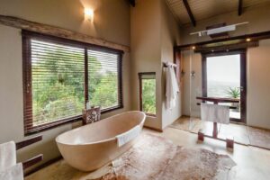 salle de bain avec baignoire ilot offrant une vue sur la nature et les animaux de la réserve