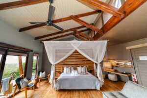 chambre et lit avec moustiquaire dans une villa de l'hôtel Rhino Ridge Safari Lodge