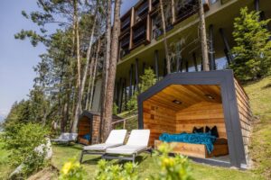 extérieur du spa de l'hôtel avec transat et petite cabane en bois à la façade ouverte sur l'extérieur pour profiter de la vue sur les montagnes sans vis à vis