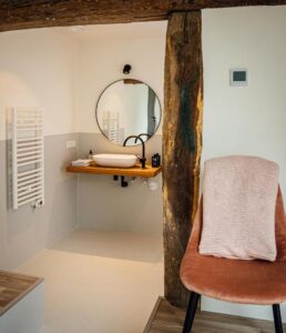 salle de douche avec poutre apparente dans une vieille ferme du 19ème rénovée en restaurant et chambre d'hôtes